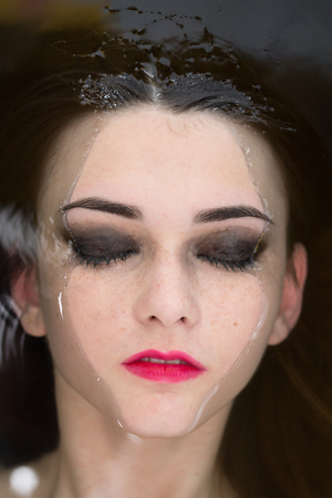 Young beautiful woman lying in water with closed eyesの写真素材