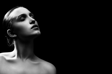 sad pensive woman on black background, image with copy space, monochromeの写真素材