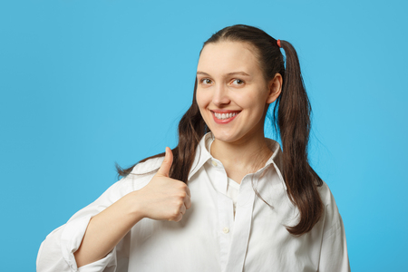 happy girl on blue background show her thumb smilingの写真素材
