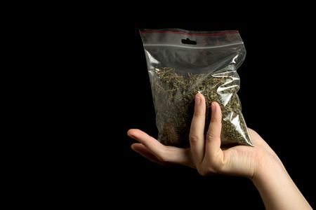 hand with pack of marijuana on black backgroundの写真素材
