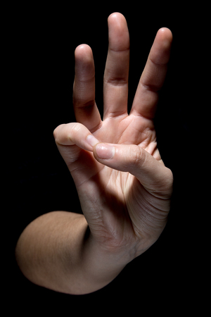hand in mudra gesture position on black backgroundの写真素材