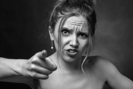 angry beautiful woman point at camera screamingの写真素材