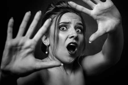 fun stressed scared girl in dark looking at camera screaming, monochromeの写真素材