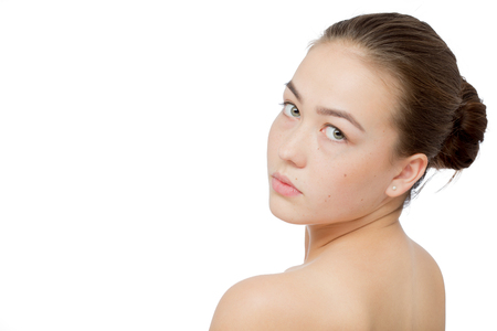 sad girl with clean skin isolated on white background with copy space looking back over shoulderの写真素材