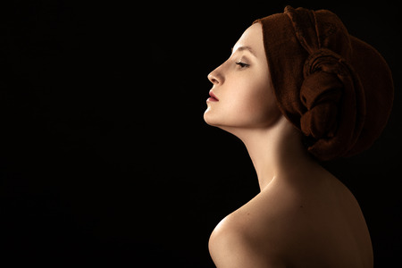 young sensual topless woman with closed eyes in turban on black background with copy spaceの写真素材