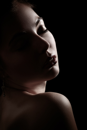 sensual female portrait with closed eyes on black backgroundの写真素材