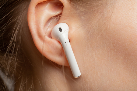 female ear with airpods earphone closeup view