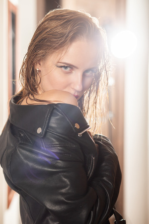sensual bare blond girl in leather jacket looking at cameraの写真素材