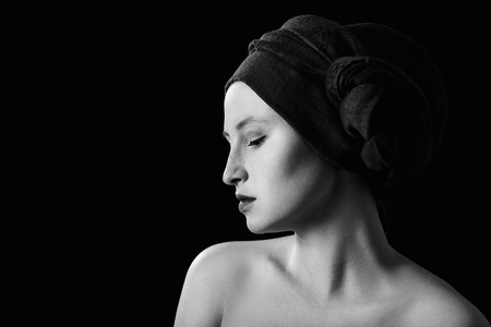 young sensual topless woman with closed eyes in turban on black background with copy space, monochromeの写真素材