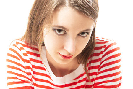 sly young woman smiling looking at camera on white backgroundの写真素材