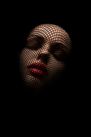 serious female beautiful face with stocking on head, black background, closed eyes, monochrome