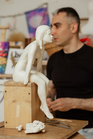 sculptor making the girl's figurine of white clayの写真素材