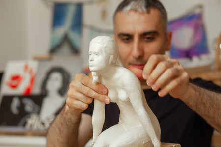 sculptor making the girl's figurine of white clayの写真素材