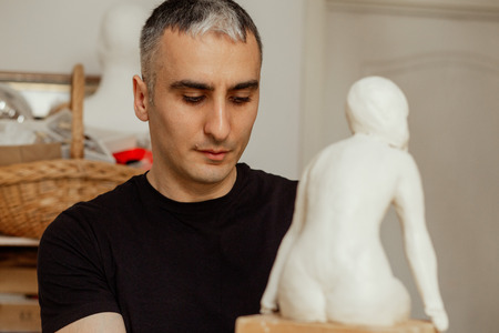 sculptor making the girl's figurine of white clayの写真素材