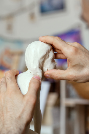 sculptor making the girl's figurine of white clayの写真素材