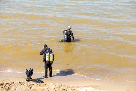 SVETLOGORSK, RUSSIA - MAY 22, 2019: two professional divers on sand sea coast before diving at Baltic seaの写真素材