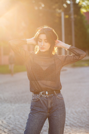 beautiful young woman on street in sunny backlightの写真素材
