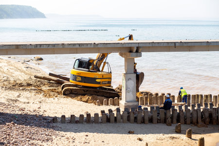 SVETLOGORSK, RUSSIA - MAY 22, 2019: excavator working on sand sea coast at Baltic sea near Svetlogorsk, Russiaのeditorial素材