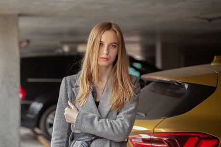 sad young woman at underground parking looking at cameraの写真素材