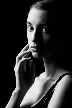 beautiful sad pensive sensual young woman on black background looking at camera, monochromeの写真素材