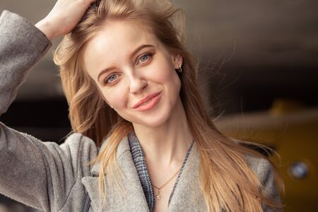 beautiful young luxury woman with long blond hair looking at camera smiling