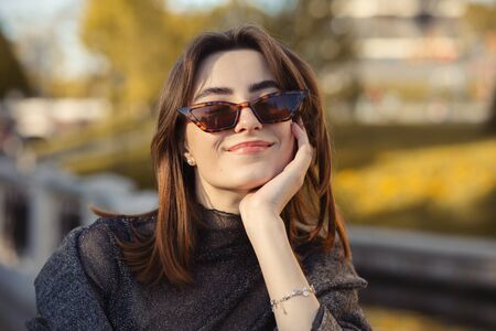 beautiful happy luxury young woman in sunny autumn park smiling with closed eyes