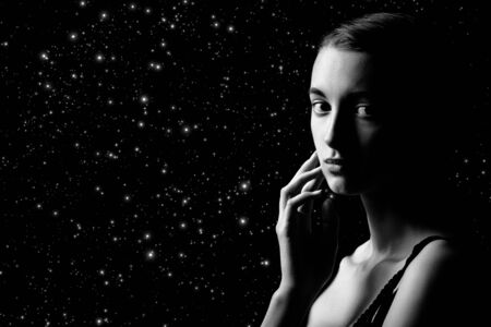 beautiful sad pensive sensual young woman on stars background with copy space looking at camera, monochromeの写真素材