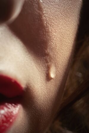sad woman crying, tear on cheek closeup portraitの写真素材