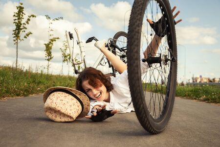 girl fell from the bicycle, lies on asphalt shoutsの写真素材
