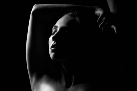 sensual woman, closed eyes on black background, monochromeの写真素材
