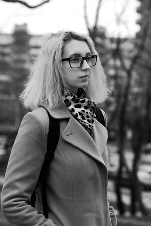 sad young woman walking at old autumn park, monochromeの写真素材