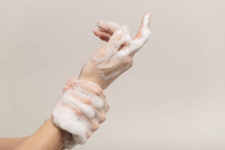 woman washing her arms closeup side view on white background