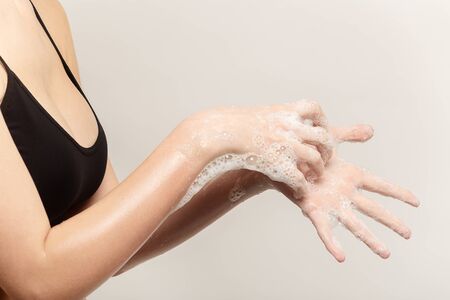 woman washing her arms closeup side view on white backgroundの写真素材