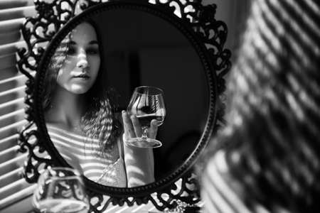 sensual beautiful woman lying in sunlight with blinds shadows, dreaming, monochromeの写真素材