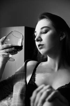 sensual beautiful woman lying in sunlight with blinds shadows, dreaming, monochromeの写真素材