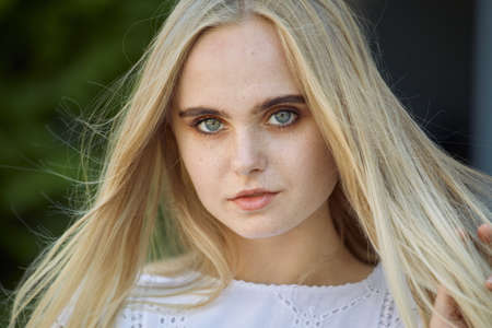 attractive blond girl with freckles looking at camera