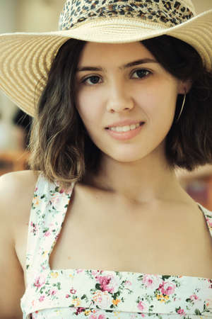 beautiful attractive young woman with natural makeup and hat looking at camera closeup portrait