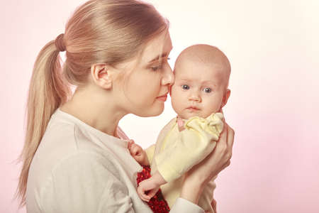 mother with newborn on her hands, kissing him