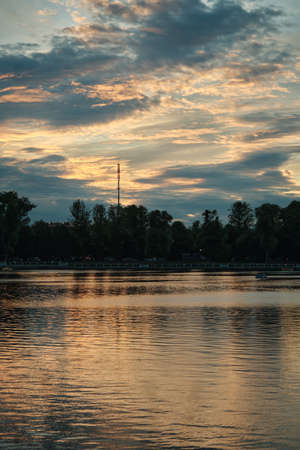 beautiful sunset with golden clouds over city pondの写真素材