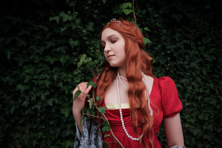 young woman with long red hair and victorian dressの写真素材
