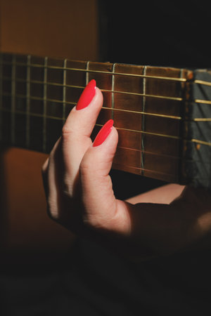 female hand with guitar strings plays closeup