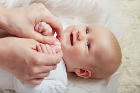 kid with mom lying on white fur smiling closeup portrait