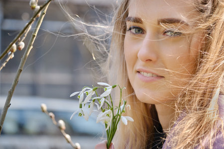 young blond woman with snowdrop bouquet at spring timeの写真素材