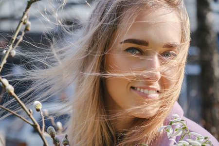 young blond woman with snowdrop bouquet at spring timeの写真素材