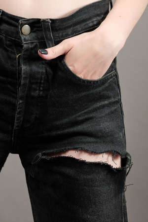 beautiful slim female legs in ripped jeans close upの写真素材