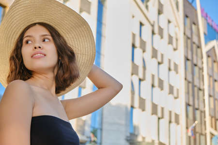 cute young woman at sunny street in european city smiling, looking asideの写真素材