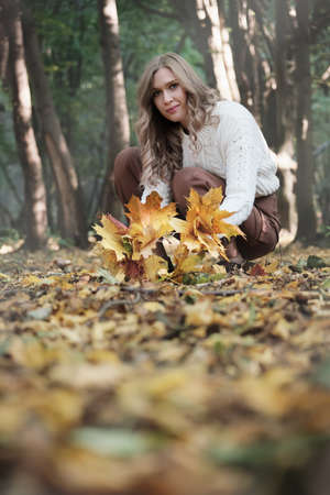 happy autumn woman posing in sunny park, looking at camera