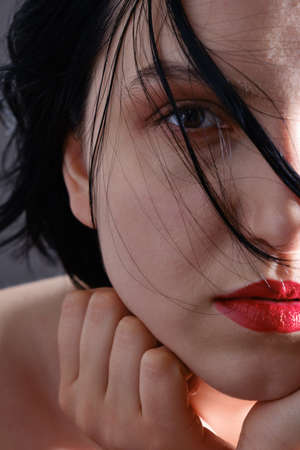 sad female closeup portrait. Young pensive woman looking at camera on gray background
