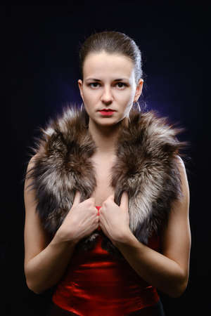 woman wearing red dress and fur in retro style on dark blue backgroundの写真素材