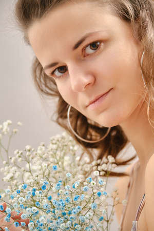 young happy woman in dress posing with flowers smilingの写真素材